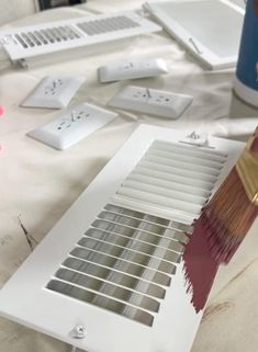 a person holding a paint brush over a window sill with other items on the table