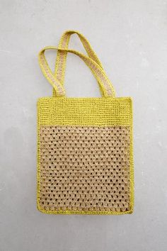 a yellow bag hanging from the side on a white wall with no people around it