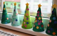 small christmas trees are lined up on the window sill