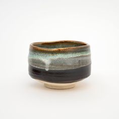 a black and brown bowl sitting on top of a white table