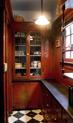 a kitchen with wooden cabinets and black and white checkered flooring