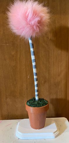 a pink pom - pom on top of a potted plant