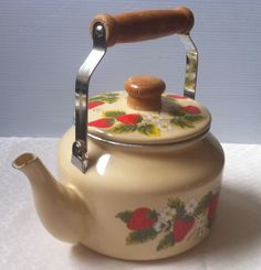 a tea kettle with a wooden handle on a table