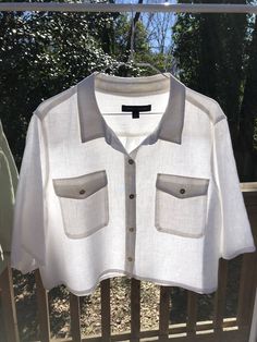 "This is a white linen blouse with half sleeves. The sleeves and the bottom were cropped to create a modern look. The Material is 100% linen which feels great during hot summer days. The size is XL. It features a collar, button front closure, two pockets on front and pleat at back. The buttons are beautiful shell buttons. Measurements: front length: 20\" 1/2 chest width: 24\" 1/2 hem width: 24\" sleeve length: 13\"" White Cropped Shirt For Spring, Summer Tops With Pockets And 3/4 Sleeves, White Button-up Crop Top For Summer, White Collared Crop Top For Summer, White Crop Top For Workwear In Summer, White Crop Top For Summer Workwear, Cropped Spring Blouse With Pockets, Spring Cropped Blouse With Pockets, Cropped Linen Blouse For Day Out