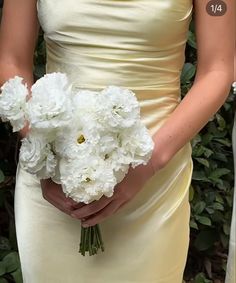 a woman holding a bouquet of white flowers