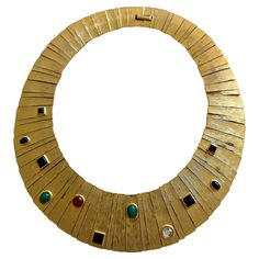 This exquisite vintage Les Bernard cabochon collar necklace is a striking example of the brand's iconic designs from the 1960s-1980s. Crafted with a bold and elegant pale gold-tone finish, the necklace features a series of multi-colored cabochon imitation stones, designed to mimic lapis, onyx, carnelian, and malachite, meticulously set in a radiant collar style, embodying an Egyptian Revival motif. Size: Approximately 14.5" inner circumference. The width varies across the design from 3/4" wide a Gold Collar Necklace, Vintage Choker Necklace, Choker Collar Necklace, Statement Collar Necklace, Black Choker Necklace, Vintage Choker, Egyptian Jewelry, Egyptian Revival, Black Choker