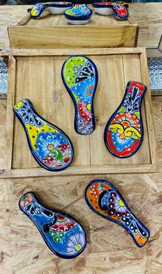 four pairs of colorful painted shoes in a wooden box