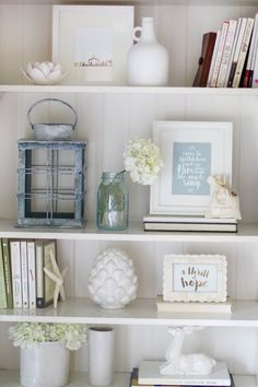 a shelf filled with books and vases on top of it