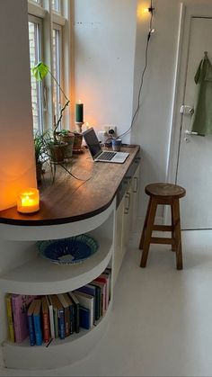 a room with a desk, stool and bookshelf