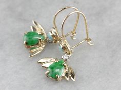 "We love the color in these vintage drop earrings, the bright green jade centers with the winged gold backs gives the appearance of a stylized bat, the soft turquoise gemstones, and small sparkling diamonds add a pop of color and flash to these fantastic drop earrings! Metal: 14K Yellow Gold Gem: Jade Gem Measurements: 7 x 5 mm, Pear Cut Accents: 2 Turquoise, 2 Diamonds totaling .06 Carats Earrings Length: 26 mm Earrings Width: 14 mm Marks: \"14K\" Stamped SKU #: 406N76AM Each piece has been ide Soft Turquoise, Vintage Drop Earrings, Cameo Ring, Earrings Metal, Golf Tees, July Birthstone, Outdoor Games, Green Jade, Turquoise Earrings