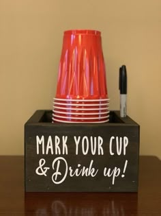 a cup and some cups on a table with marker writing that says, mark your cup & drink up