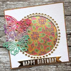 a happy birthday card with an ornate design on the front, and a colorful butterfly in the middle