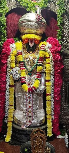 the statue is decorated with flowers and garlands