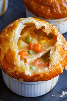 two pot pies filled with different types of food on top of a table next to each other