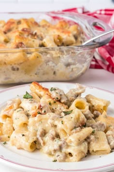 a white plate topped with macaroni and cheese next to a casserole dish