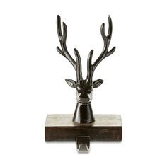 a metal deer head mounted on top of a wooden block with an iron hook in the middle