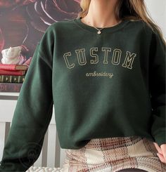 * Your custom text embroidered on super soft and comfortable 50/50 cotton/poly sweatshirt. * Sizes are in Unisex/Men's sizing and runs normal. * Size charts shows the sweatshirt measurement when it is laid flat. * We DO NOT send mockups for this item.  If you have to have a mockup, please Zelle or Venmo $15 to info@camelsota.com with your order number and message to let me know.  Your order processing time will increase by 3-5 business days. Winter Crew Sweats With Embroidered Logo, Green Winter Sweatshirt With Embroidered Logo, Winter Green Sweatshirt With Embroidered Logo, Green Long Sleeve Sweater With Embroidered Text, College Embroidered Fleece Top, Embroidered Fleece Tops For College, Sporty Embroidered Fleece Sweatshirt, Varsity Sweatshirt With Custom Embroidery For Fall, College Winter Sweater With Embroidered Graphics