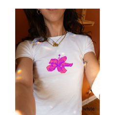 🌺 Feel the early 2000s vibe with this eye-catching purple hibiscus graphic tee! Perfect for those who love bold, floral designs, this t-shirt combines the charm of the Y2K aesthetic with a coquette touch. Made with soft, breathable fabric, it's ideal for a casual day out or a funky party night. Get ready to stand out in this vibrant, retro-inspired piece! 🌟  Looking for a graphic baby tee nostalgic of the 90s? Bring your Y2K outfit dreams to life with our newest collection. This classic baby t Y2k Purple Graphic Print Top, Fitted Floral Print Graphic Tee, Purple Y2k Style Graphic Print T-shirt, Purple Y2k Graphic Print T-shirt, Purple Y2k Style Graphic T-shirt, Y2k Style Purple Graphic Print T-shirt, Purple Y2k Cotton T-shirt, White Hibiscus Print Crew Neck T-shirt, White Crew Neck T-shirt With Hibiscus Print