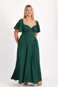 a woman in a green dress posing for the camera