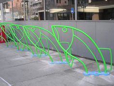 several green sculptures on the side of a building