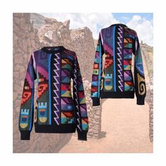 a colorful sweater is hanging on a clothes line in front of a stone wall and dirt path