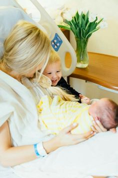 a woman holding a baby in a hospital bed