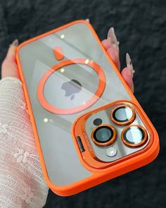 an orange iphone case with circles on the front and sides is held in someone's hand