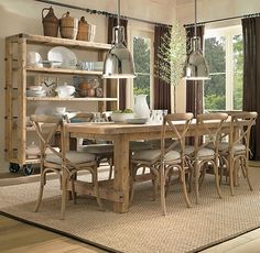 a dining room table with chairs and plates on it in front of a bookcase