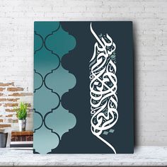 an arabic calligraphy on a wall above a table with a potted plant in the corner