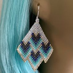 a close up of a pair of earrings on a mannequin's head