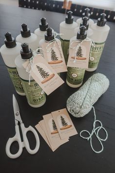 several bottles of hand sanitizers are sitting on a table next to yarn and scissors