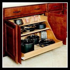 an open cabinet with pots and pans in it