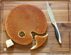 a pancake that has been cut in half and is on a cutting board with a knife