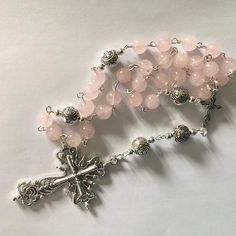 Beautiful natural Rose Quartz Anglican prayer beads o I have made this using rose Quartz beads, Tibetan silver beads,  Silver plated spacer beads, Tibetan connecter, Tibetan cross and finished with silver tone wire work The cross measures 2" Thank you for visiting my shop. If there is a particular piece you like but would prefer it in another colour, shortened or lengthened please contact me I can usually meet your requirements  A pretty silk brocade pouch is available for you to keep your item Anglican Prayer Beads, Jewellery Pouch, Semi Precious Gems, Rose Quartz Beads, Quartz Beads, Silk Brocade, Quartz Rose, Wire Work, Precious Gems