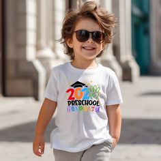 a young boy wearing sunglasses and a t - shirt with the words preschool on it