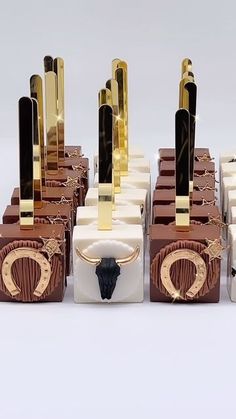 several pieces of chocolate with gold trimmings and black handles on each one side