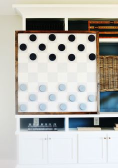 an entertainment center with white cabinets and black dots on the wall