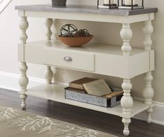 a white shelf with two candles and a bowl on it next to a stair case