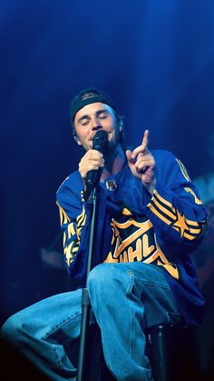 a man sitting on top of a chair while holding a microphone in his right hand