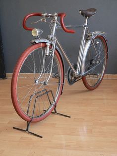 a red and silver bicycle is parked on the floor