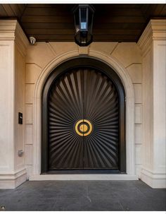 an entrance to a building with a clock on the front door and light above it