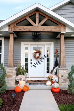 a front porch decorated for halloween with pumpkins and decorations