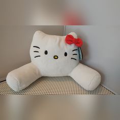 a hello kitty stuffed animal with a red bow on it's head sitting on a table