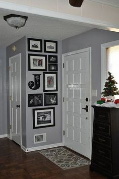 a living room with pictures on the wall and a christmas tree in front of it