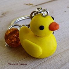 a yellow rubber ducky keychain with a crystal bead in it's mouth