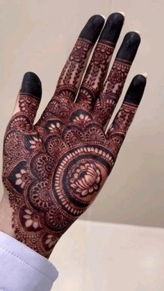 a woman's hand with henna tattoos on it