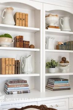 white bookcases with books and vases on them