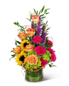 a vase filled with lots of different colored flowers