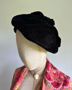 This beautiful vintage hat features beret styling, with a fitted band and soft, floppy top accented with a top-knot bow. Delicate and feminine with striking black silk-velvet to frame the face. Excellent vintage condition. Era: 1930s  Label: black and white hatters and milliners union label Pictured on a mannequin with a 21 inch head circumference Elegant Black Beret For Party, Victorian Fitted Hats For Evening, Fitted Victorian Hat For Evening, Adjustable Brimmed Elegant Beret, Elegant Adjustable Black Beret, Elegant Fall Beret, Elegant Fitted Beret, Elegant Fitted Beret For Parties, Vintage Black Beret For Fall