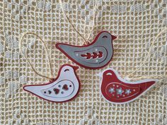 three red and white bird ornaments hanging from string